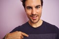 Young handsome man wearing casual t-shirt standing over isolated pink background with surprise face pointing finger to himself Royalty Free Stock Photo