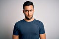 Young handsome man wearing casual t-shirt standing over isolated white background depressed and worry for distress, crying angry Royalty Free Stock Photo