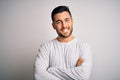 Young handsome man wearing casual t-shirt standing over isolated white background happy face smiling with crossed arms looking at Royalty Free Stock Photo