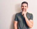 Young handsome man wearing casual t-shirt standing over isolated white background smiling looking confident at the camera with Royalty Free Stock Photo