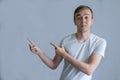 Young handsome man wearing casual white shirt pointing something on his side with his hand over gray background Royalty Free Stock Photo