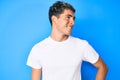 Young handsome man wearing casual white t shirt looking away to side with smile on face, natural expression Royalty Free Stock Photo