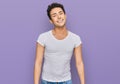 Young handsome man wearing casual white t shirt looking positive and happy standing and smiling with a confident smile showing Royalty Free Stock Photo