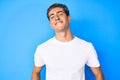 Young handsome man wearing casual white t shirt looking positive and happy standing and smiling with a confident smile showing Royalty Free Stock Photo