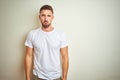 Young handsome man wearing casual white t-shirt over isolated background depressed and worry for distress, crying angry and afraid Royalty Free Stock Photo