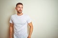 Young handsome man wearing casual white t-shirt over isolated background smiling looking to the side and staring away thinking Royalty Free Stock Photo