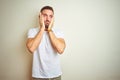 Young handsome man wearing casual white t-shirt over isolated background Tired hands covering face, depression and sadness, upset Royalty Free Stock Photo