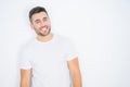 Young handsome man wearing casual white t-shirt over white isolated background looking away to side with smile on face, natural Royalty Free Stock Photo