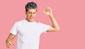 Young handsome man wearing casual white tshirt dancing happy and cheerful, smiling moving casual and confident listening to music Royalty Free Stock Photo