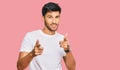 Young handsome man wearing casual white tshirt pointing fingers to camera with happy and funny face Royalty Free Stock Photo