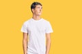 Young handsome man wearing casual white tshirt smiling looking to the side and staring away thinking Royalty Free Stock Photo