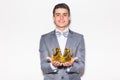 Young handsome man wearing with crown in hands suit looking at camera Royalty Free Stock Photo