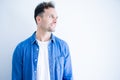 Young handsome man wearing denim shirt standing over isolated white background looking away to side with smile on face, natural Royalty Free Stock Photo