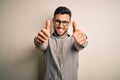 Young handsome man wearing elegant shirt and glasses over isolated white background approving doing positive gesture with hand, Royalty Free Stock Photo