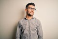 Young handsome man wearing elegant shirt and glasses over isolated white background looking away to side with smile on face, Royalty Free Stock Photo