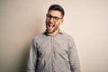 Young handsome man wearing elegant shirt and glasses over isolated white background winking looking at the camera with sexy Royalty Free Stock Photo