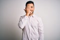 Young handsome man wearing elegant shirt standing over isolated white background covering one eye with hand, confident smile on Royalty Free Stock Photo