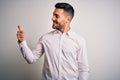 Young handsome man wearing elegant shirt standing over isolated white background Looking proud, smiling doing thumbs up gesture to Royalty Free Stock Photo