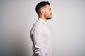 Young handsome man wearing elegant shirt standing over isolated white background looking to side, relax profile pose with natural Royalty Free Stock Photo