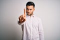 Young handsome man wearing elegant shirt standing over isolated white background Pointing with finger up and angry expression, Royalty Free Stock Photo