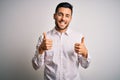 Young handsome man wearing elegant shirt standing over isolated white background success sign doing positive gesture with hand, Royalty Free Stock Photo