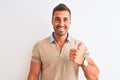 Young handsome man wearing elegant t-shirt over isolated background doing happy thumbs up gesture with hand Royalty Free Stock Photo