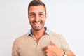 Young handsome man wearing elegant t-shirt over isolated background with surprise face pointing finger to himself Royalty Free Stock Photo