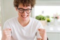 Young handsome man wearing glasses excited for success with arms raised celebrating victory smiling Royalty Free Stock Photo