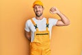 Young handsome man wearing handyman uniform over yellow background stretching back, tired and relaxed, sleepy and yawning for Royalty Free Stock Photo
