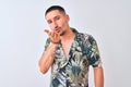 Young handsome man wearing Hawaiian summer shirt over isolated background looking at the camera blowing a kiss with hand on air Royalty Free Stock Photo