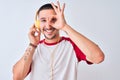 Young handsome man wearing headphones over isolated background with happy face smiling doing ok sign with hand on eye looking Royalty Free Stock Photo