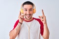 Young handsome man wearing headphones over isolated background surprised with an idea or question pointing finger with happy face, Royalty Free Stock Photo