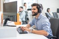 Young handsome man wearing headset working on computer in call center. Royalty Free Stock Photo