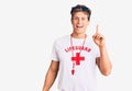 Young handsome man wearing lifeguard t shirt and whistle pointing finger up with successful idea