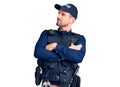 Young handsome man wearing police uniform looking to the side with arms crossed convinced and confident Royalty Free Stock Photo