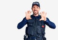 Young handsome man wearing police uniform smiling funny doing claw gesture as cat, aggressive and sexy expression Royalty Free Stock Photo