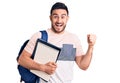 Young handsome man wearing student backpack and notebook screaming proud, celebrating victory and success very excited with raised Royalty Free Stock Photo