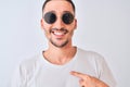 Young handsome man wearing sunglasses and casual t-shirt over isolated background with surprise face pointing finger to himself Royalty Free Stock Photo