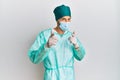 Young handsome man wearing surgeon uniform and medical mask pointing fingers to camera with happy and funny face Royalty Free Stock Photo