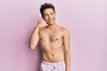 Young handsome man wearing swimwear shirtless smiling doing phone gesture with hand and fingers like talking on the telephone Royalty Free Stock Photo