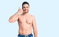 Young handsome man wearing swimwear smiling doing phone gesture with hand and fingers like talking on the telephone Royalty Free Stock Photo