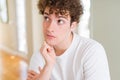 Young handsome man wearing white t-shirt with hand on chin thinking about question, pensive expression Royalty Free Stock Photo