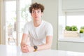 Young handsome man wearing white t-shirt at home smiling looking side and staring away thinking Royalty Free Stock Photo