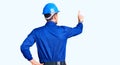 Young handsome man wearing worker uniform and hardhat backwards thinking about doubt with hand on head