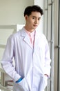 Young handsome man in white coat standing with confidence as a lab professional of scientific research for health care and medical Royalty Free Stock Photo