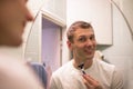 Young handsome man in white t-shirt shaves in front of bathroom mirror in the morning. Royalty Free Stock Photo