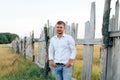 Young handsome man in a white shirt and jeans shorts outdoors Royalty Free Stock Photo