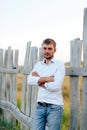 Young handsome man in a white shirt and jeans shorts outdoors Royalty Free Stock Photo