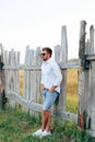 Young handsome man in a white shirt and jeans shorts outdoors Royalty Free Stock Photo