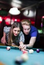 Young handsome man and woman flirting while playing snooker